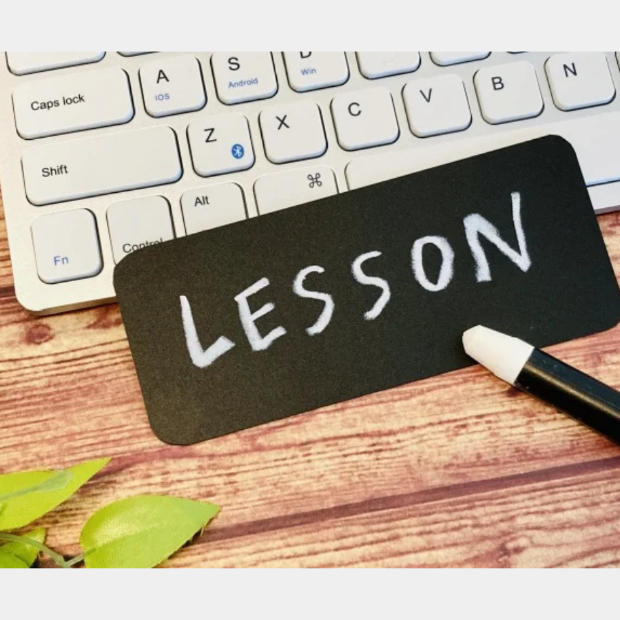オンラインで行われるパーソナルレッスンを象徴する、キーボードと「lesson」のボード