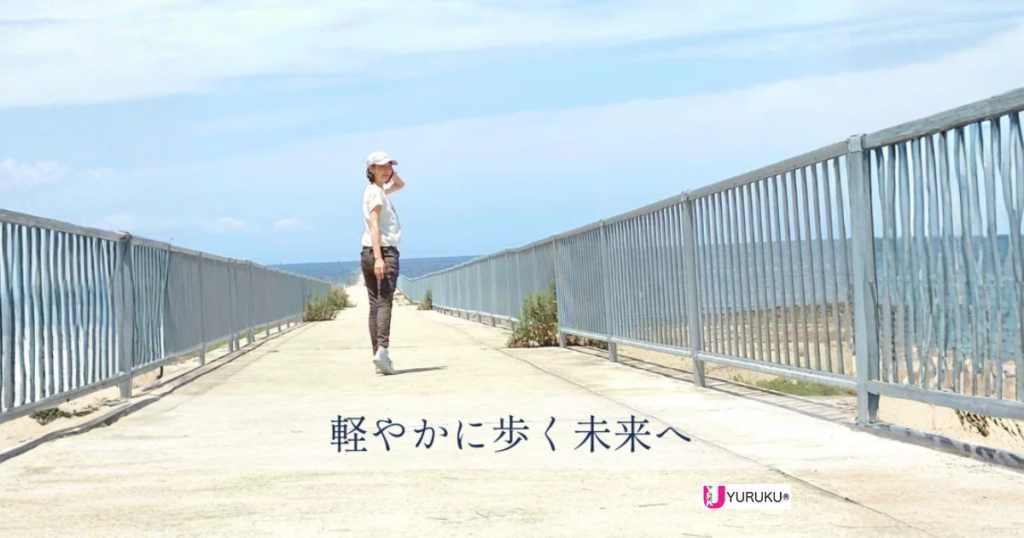 海辺の橋を歩きながら振り返る女性の後ろ姿の写真
