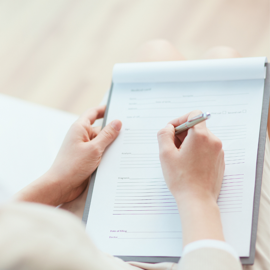 受講生のお悩みが書かれたメモを手に、レッスン内容を書き留めようとしている女性の手元