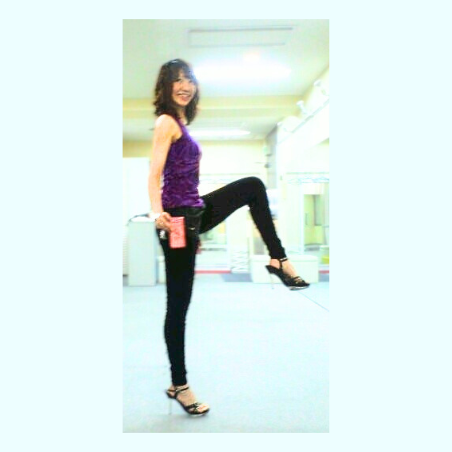 ピンヒールを履き、片足で安定して立つノリコの姿