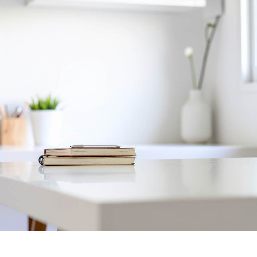 白いデスクに置かれたノートとペン。体のねじれを研究してきた過程を象徴する写真