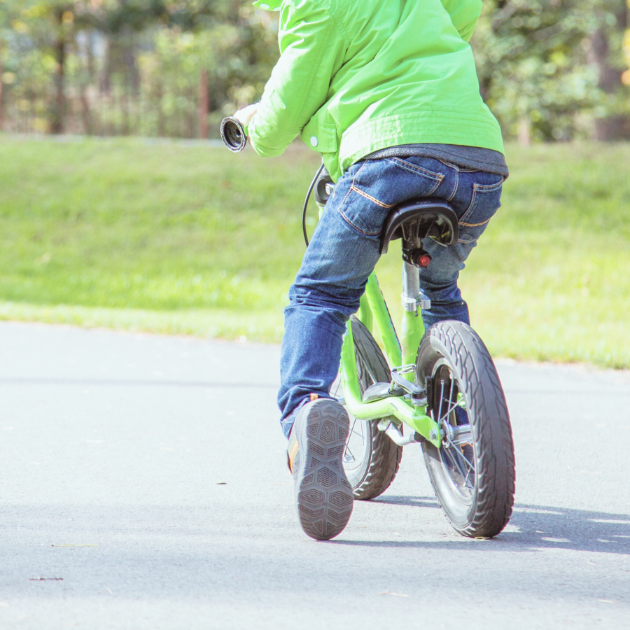 補助輪なし自転車でバランスを崩し、足を地面につく男の子