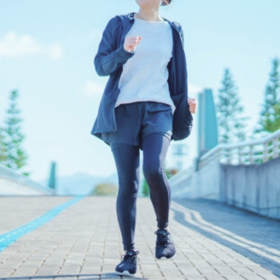 膝を高く上げて歩く女性の横向き姿