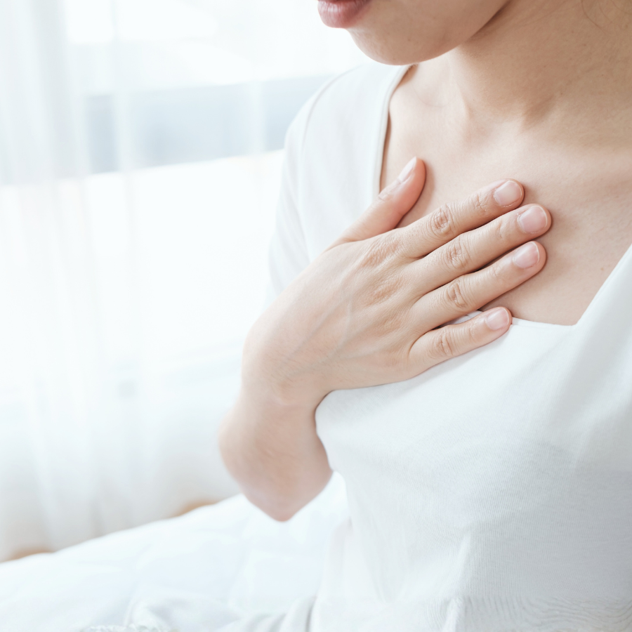 胸に手を当てて自分の感覚を感じる女性