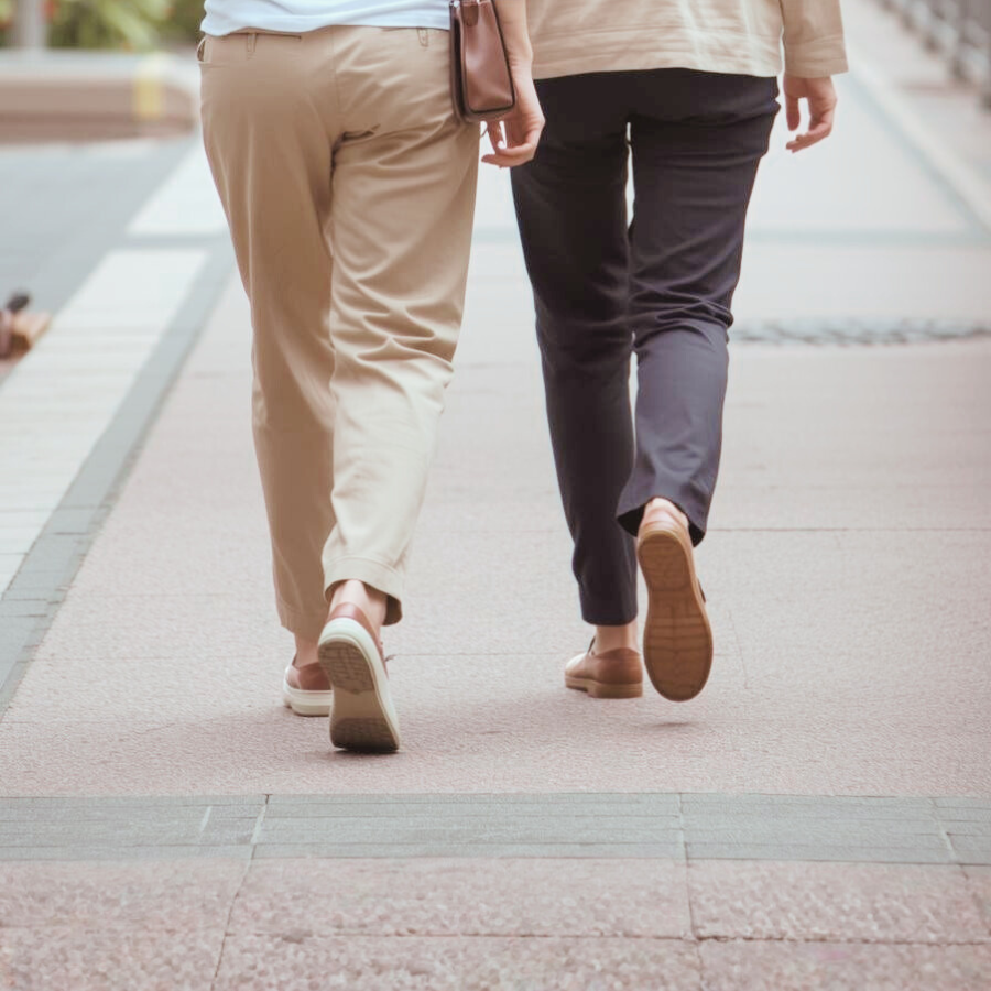 同じ方向を見て並んで立つ2人の女性の後ろ姿