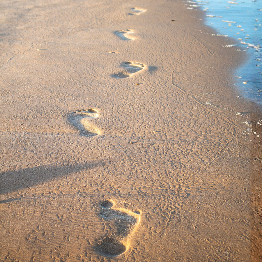 砂浜に残る足跡。自分の力で前に進むことを象徴するイメージ。